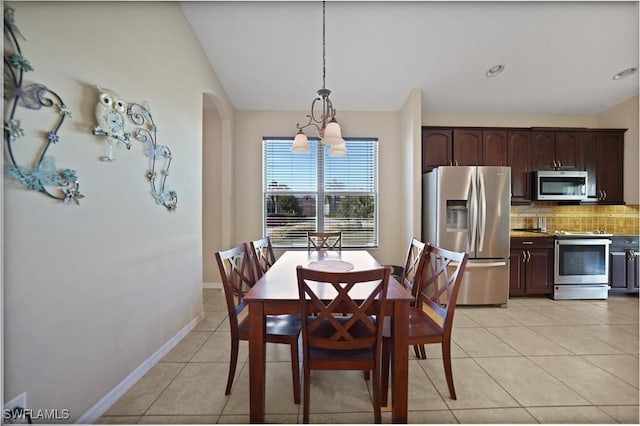 tiled dining space with a chandelier