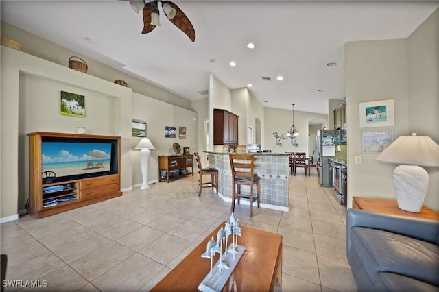 tiled living room featuring ceiling fan with notable chandelier