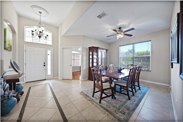 tiled dining area featuring ceiling fan with notable chandelier