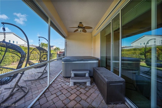 sunroom with a hot tub and ceiling fan