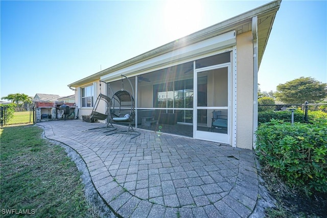 back of property with a patio and a sunroom