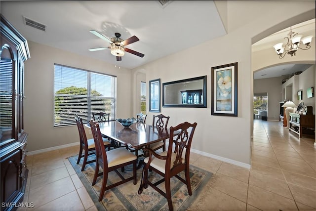 dining space featuring ceiling fan with notable chandelier and light tile patterned flooring