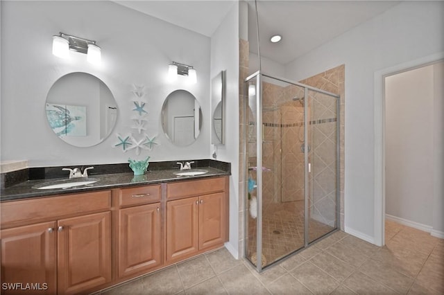 bathroom with tile patterned flooring, vanity, and a shower with door