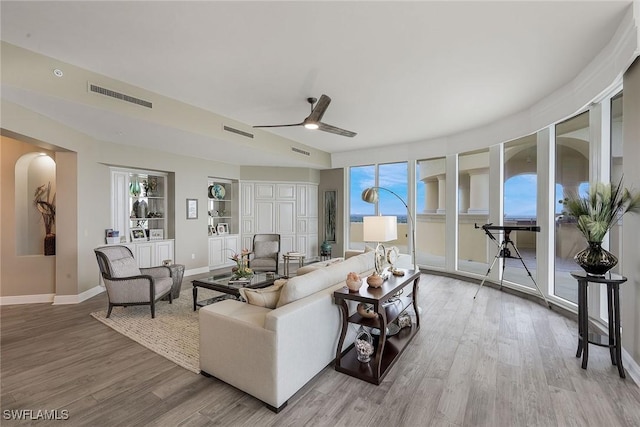 living room with ceiling fan and light hardwood / wood-style flooring