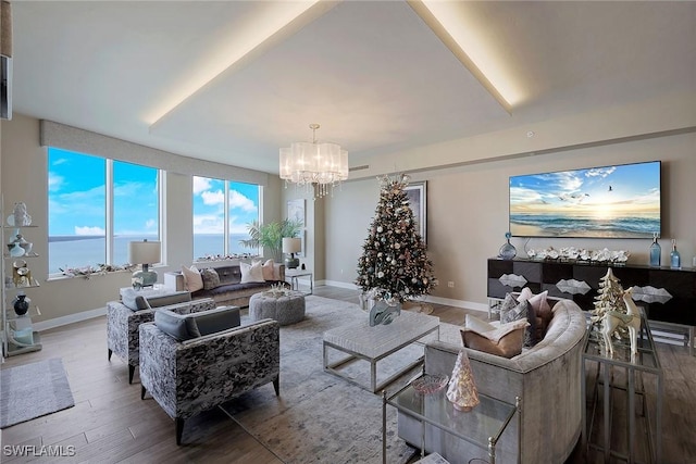 living room featuring a water view, hardwood / wood-style flooring, and a notable chandelier