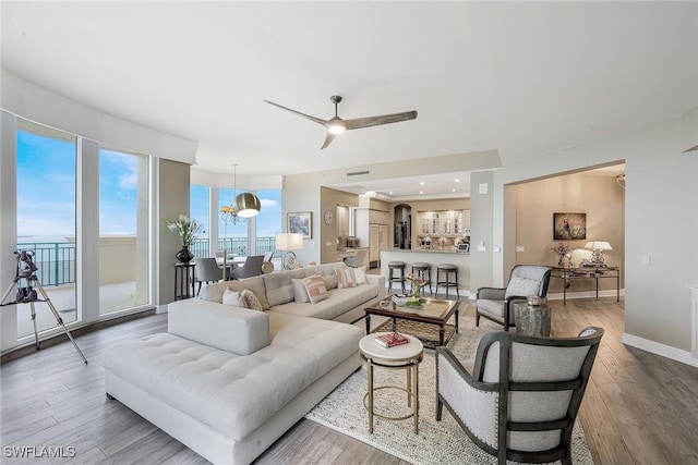 living room featuring hardwood / wood-style floors and ceiling fan with notable chandelier