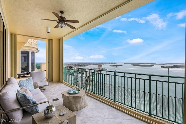 balcony with ceiling fan, a water view, and an outdoor hangout area