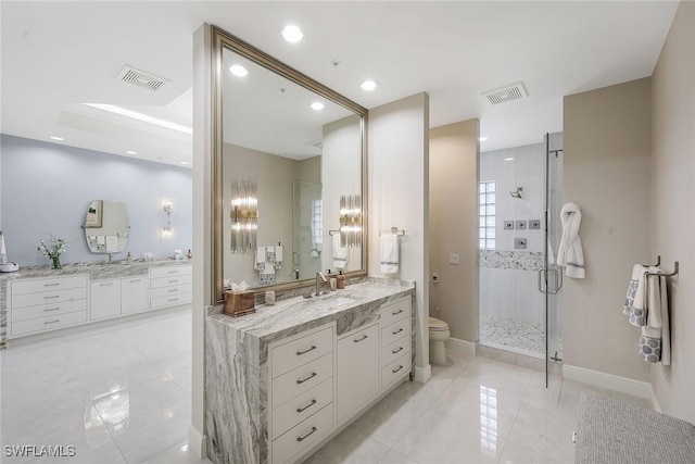 bathroom with tile patterned floors, vanity, toilet, and a shower with door