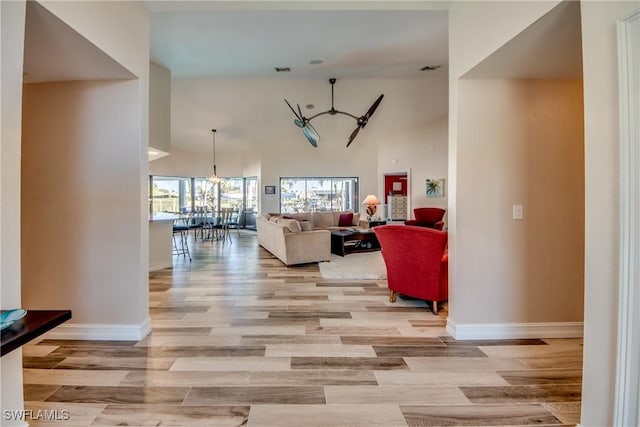 living room with high vaulted ceiling and light wood-type flooring