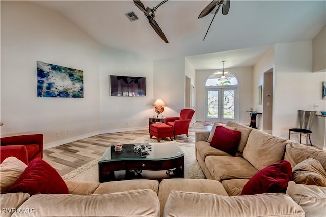 living room with ceiling fan, lofted ceiling, light hardwood / wood-style flooring, and french doors