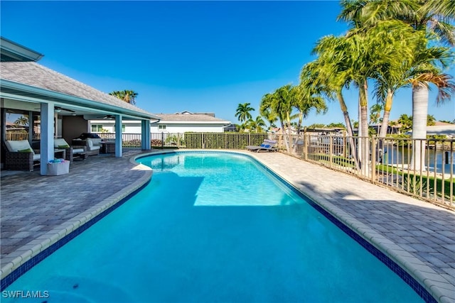 view of pool featuring a water view and a patio