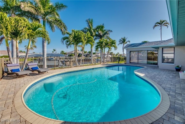 view of pool with a water view and a patio