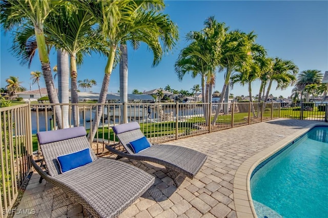 view of swimming pool featuring a patio area and a water view