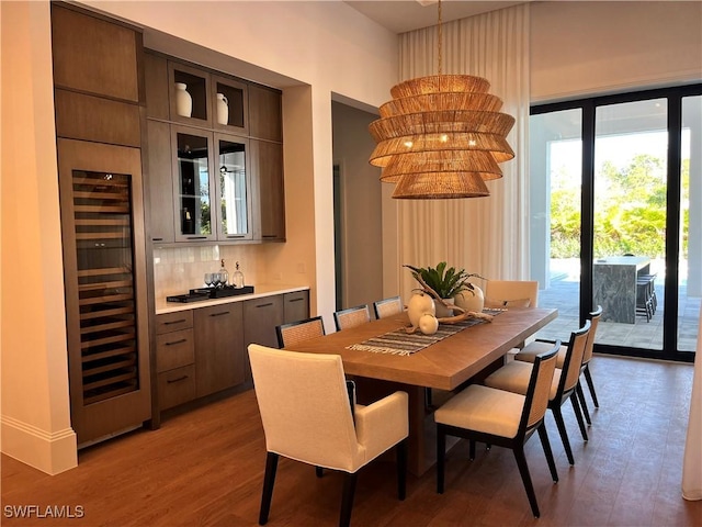 dining space featuring hardwood / wood-style floors, beverage cooler, and indoor bar