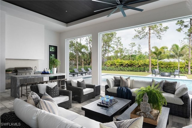 sunroom with ceiling fan and a tray ceiling