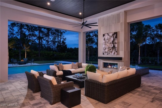 view of patio / terrace featuring a ceiling fan, an outdoor pool, and an outdoor living space with a fireplace