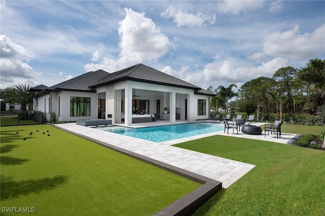 back of house with a lawn, a patio area, fence, an outdoor pool, and an outdoor living space