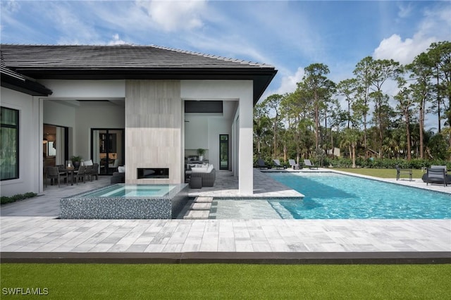 back of house featuring a patio area, an outdoor pool, and an in ground hot tub