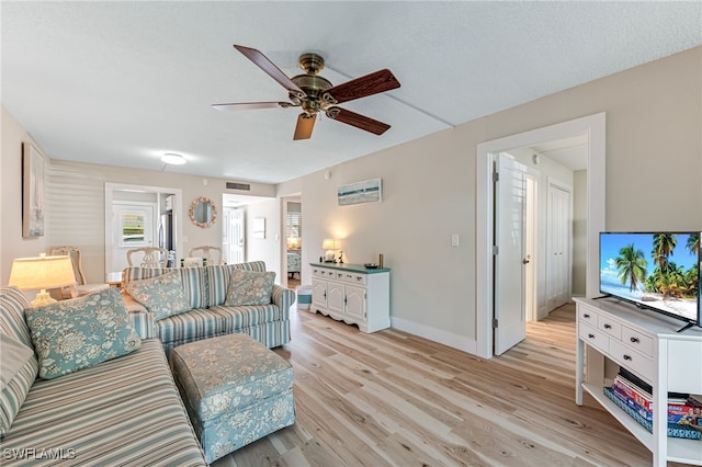 living room featuring ceiling fan and light hardwood / wood-style floors