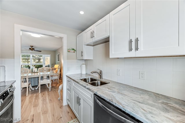 kitchen with sink, white cabinets, light stone counters, ceiling fan, and appliances with stainless steel finishes