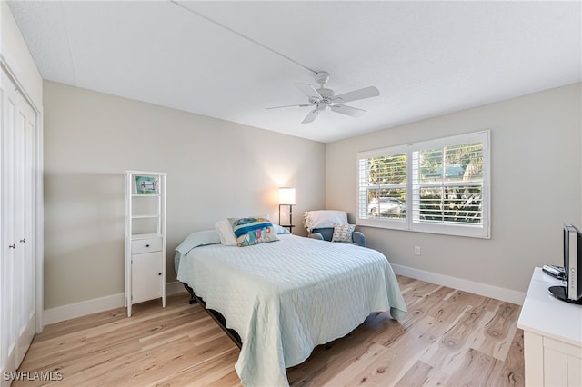 bedroom with ceiling fan, light wood-type flooring, and a closet