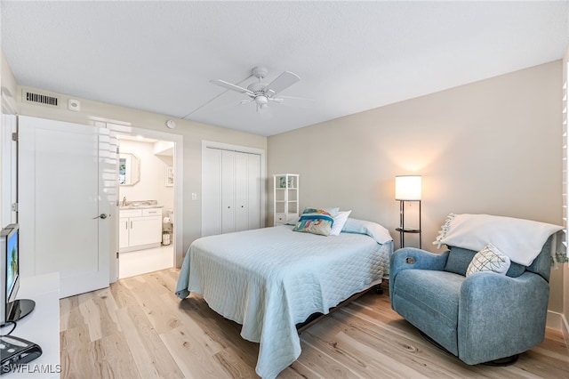 bedroom featuring ceiling fan, light hardwood / wood-style floors, connected bathroom, and a closet