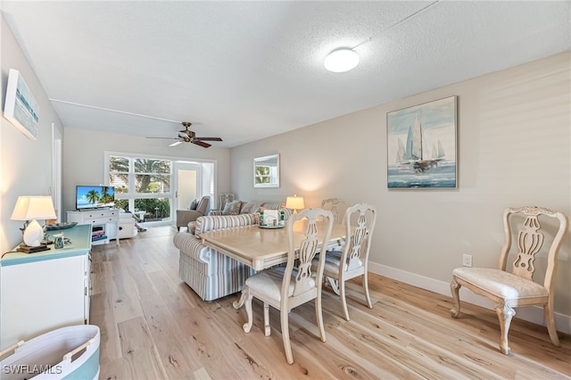 dining space featuring a textured ceiling, ceiling fan, and light hardwood / wood-style floors