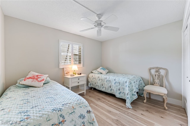 bedroom featuring a textured ceiling, ceiling fan, and light hardwood / wood-style flooring