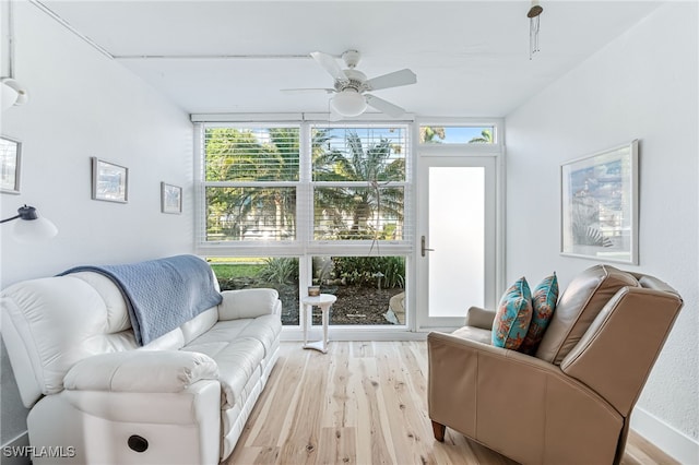 living room featuring ceiling fan, light wood-type flooring, and expansive windows