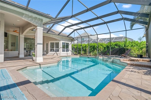 view of swimming pool with a lanai, a patio area, and ceiling fan