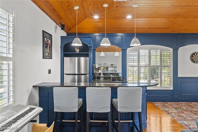 kitchen with stainless steel fridge, wooden ceiling, and blue cabinets