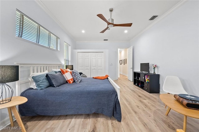 bedroom with hardwood / wood-style flooring, ornamental molding, a closet, and ceiling fan