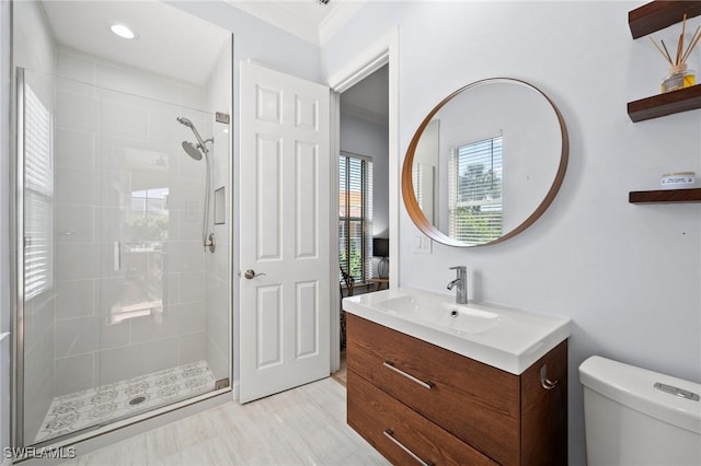 bathroom with vanity, ornamental molding, toilet, and walk in shower