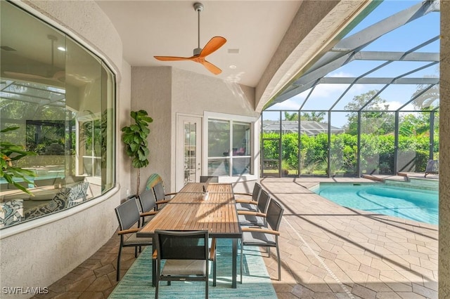 view of swimming pool with a patio, ceiling fan, and glass enclosure