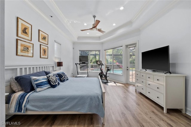 bedroom with a raised ceiling, crown molding, access to outside, and light wood-type flooring