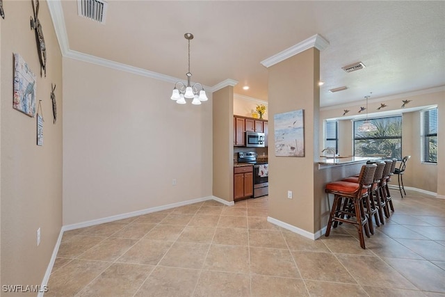 kitchen with hanging light fixtures, a kitchen breakfast bar, a notable chandelier, crown molding, and appliances with stainless steel finishes