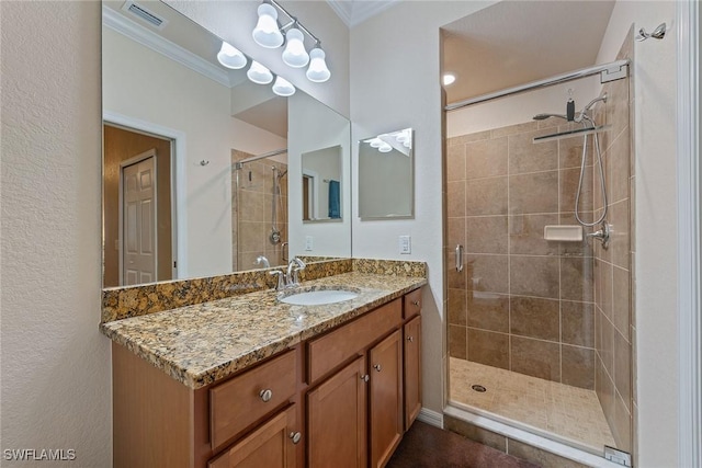 bathroom featuring a shower with door, vanity, and ornamental molding