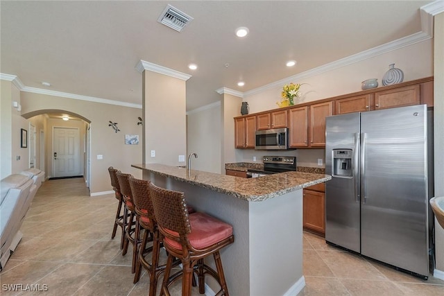 kitchen with ornamental molding, a breakfast bar, stainless steel appliances, sink, and stone countertops