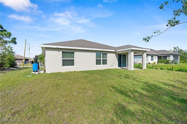 rear view of property featuring a lawn