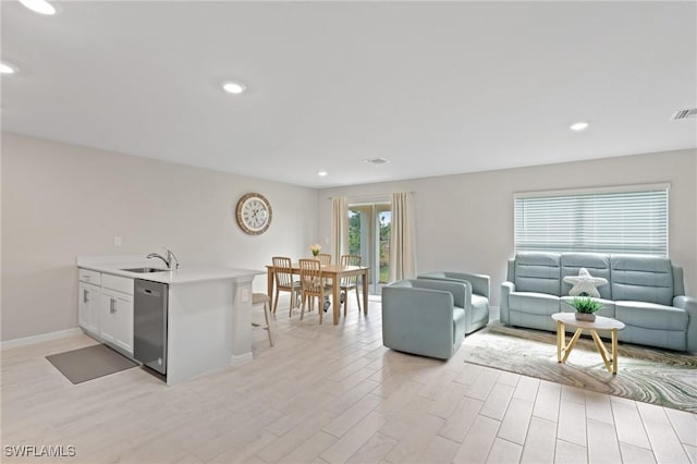 living room featuring sink and light hardwood / wood-style floors