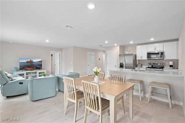 dining space featuring sink and light wood-type flooring