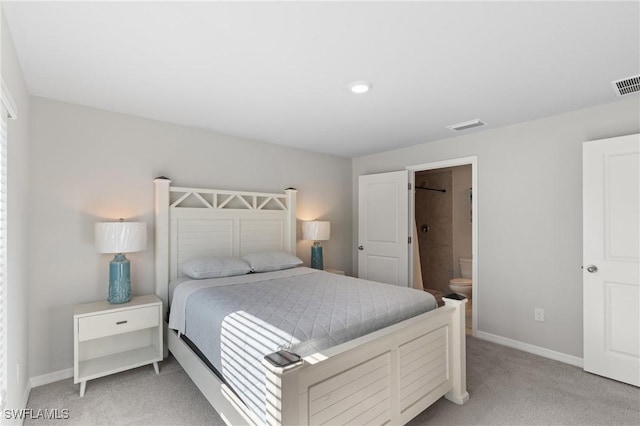 bedroom featuring light carpet and ensuite bath