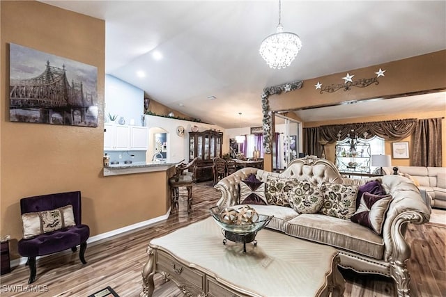 living room featuring hardwood / wood-style floors, lofted ceiling, and a chandelier