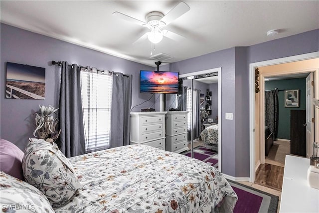 bedroom featuring hardwood / wood-style floors, ceiling fan, and a closet