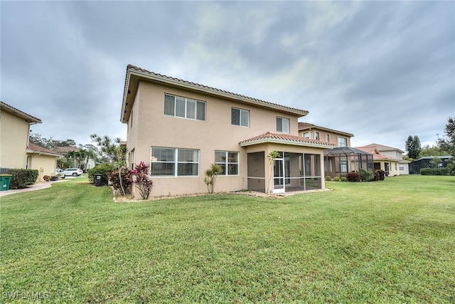 rear view of property with a lanai and a yard