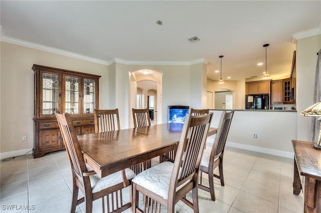 tiled dining room featuring crown molding