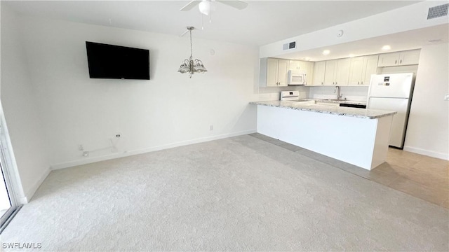100 Estero Blvd Unit 434, Fort Myers Beach, FL 33931 - kitchen featuring white appliances, baseboards, light stone countertops, a sink, and a peninsula
