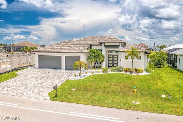 view of front of property with french doors, a garage, and a front lawn