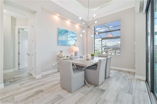 dining area with crown molding, a tray ceiling, and a chandelier