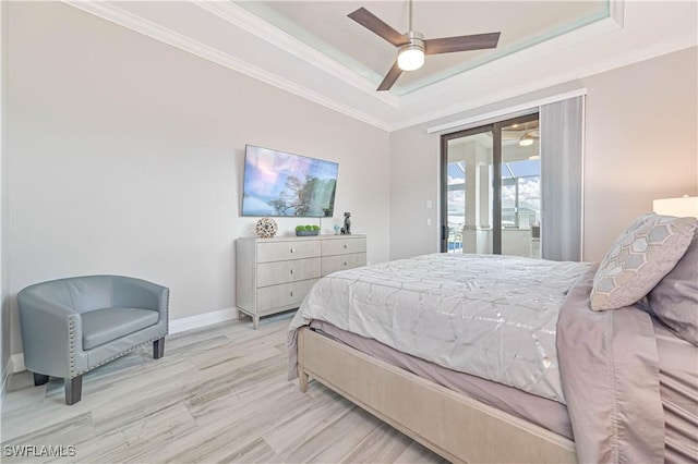 bedroom with crown molding, ceiling fan, a tray ceiling, and access to exterior